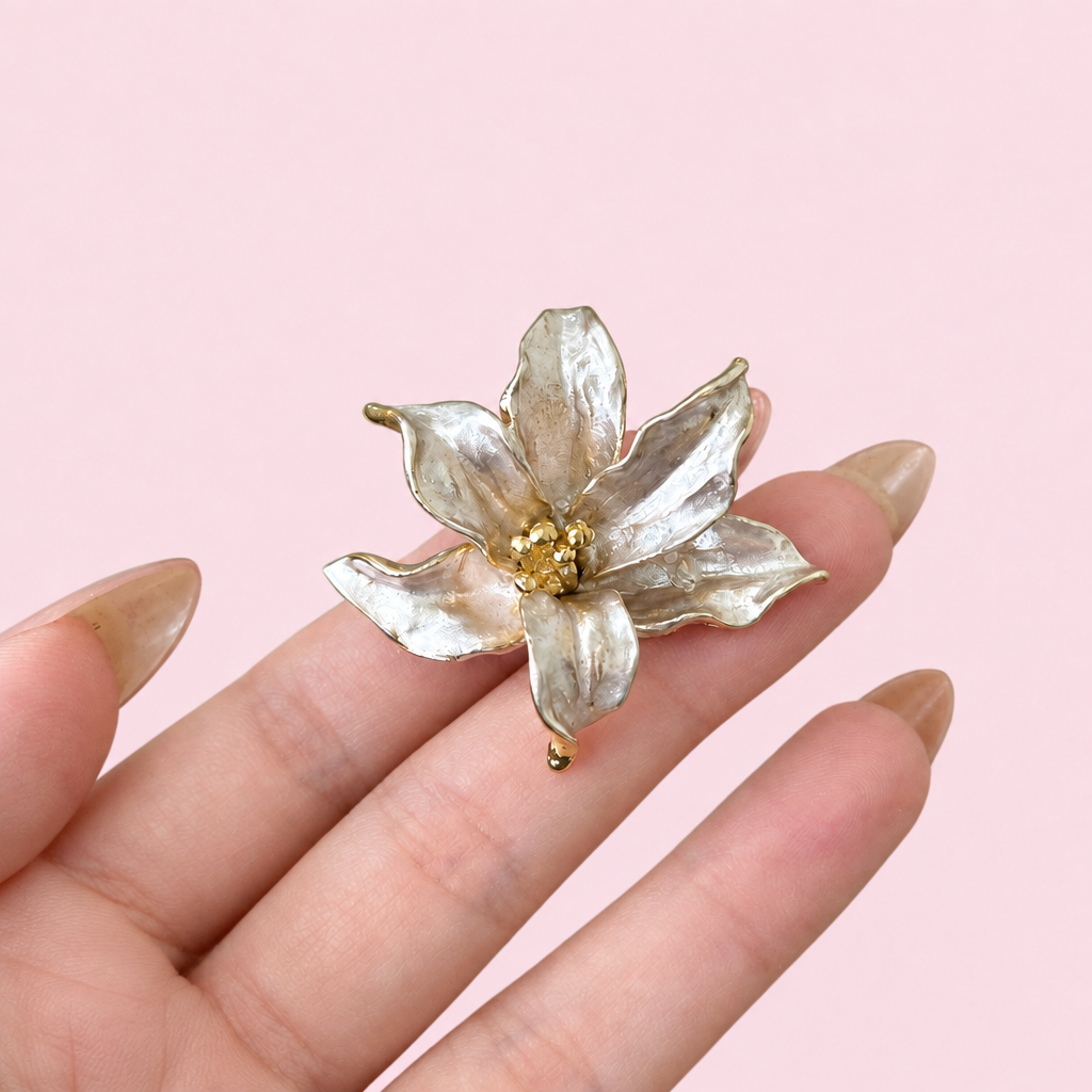 Flower ring on a hand against a light pink background